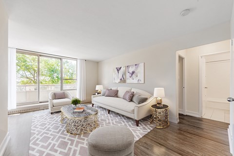 A living room with a couch, a coffee table, and a painting on the wall.